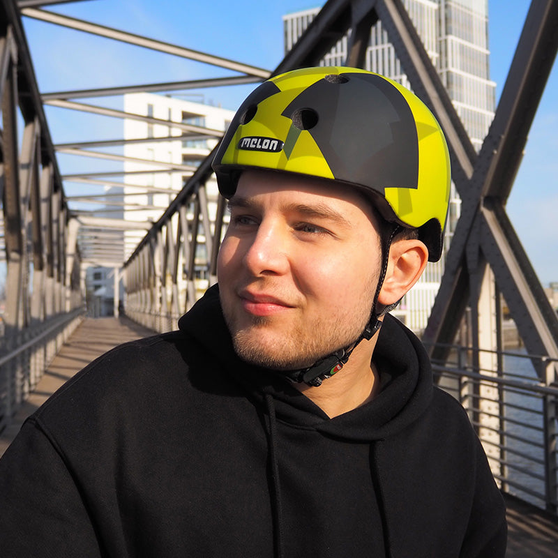 Man wearing a Melon Bumblebee Bicycle Helmet while standing on a bridge in Hamburg