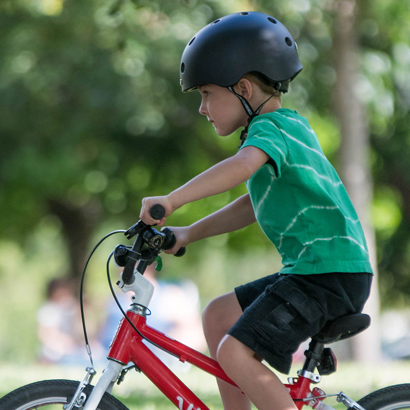 Boy riding his bike in the park while wearing a Melon "Closed Eyes" Bicycle Helmet