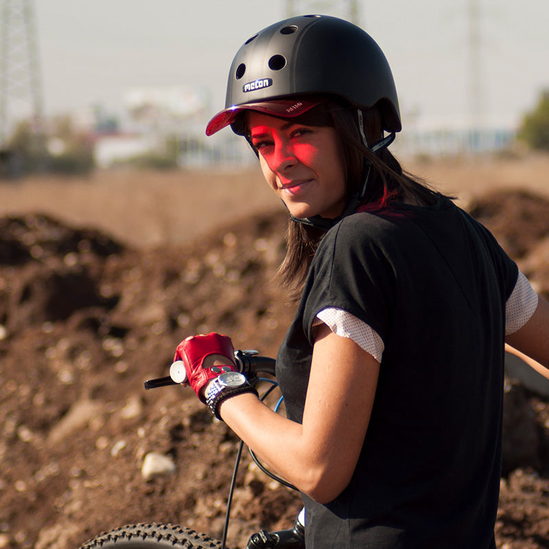 Woman dirtbiking while wearing a Melon Decent Double Black Bycicle Helmet with a red Visor