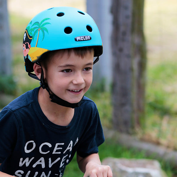 Boy wearing a blue "Little Pirate" Melon Kids Bicycle helmet 