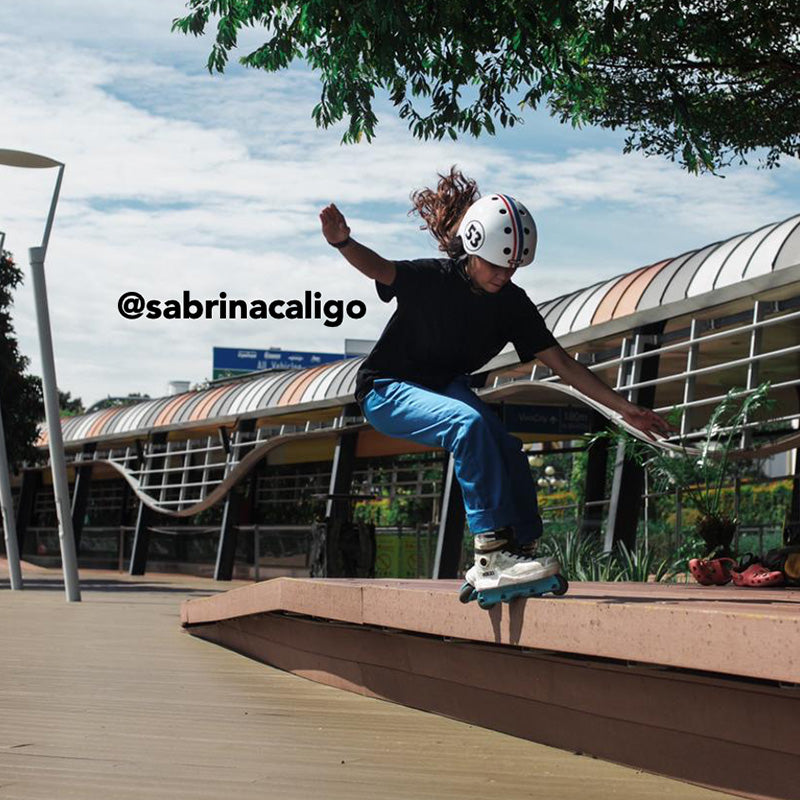 Girl doing rollerskate tricks while wearing a white Melon "Beetle" Bicycle Helmet