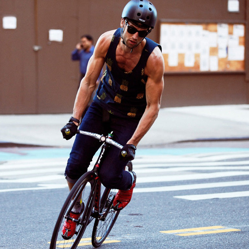 Muscular Man riding his performance Bike through the Streets of New York City while wearing a Melon Decent Double Black Bicycle Helmet