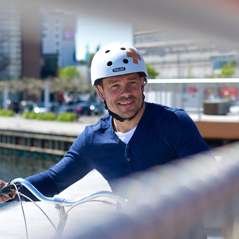 Man in Kopenhagen riding his bike wearing a Melon Plastered White Bicycle Helmet
