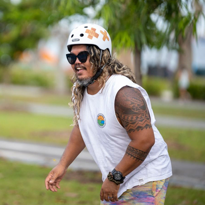 Man riding a skateboard wearing a Melon Plastered White Bike Helmet