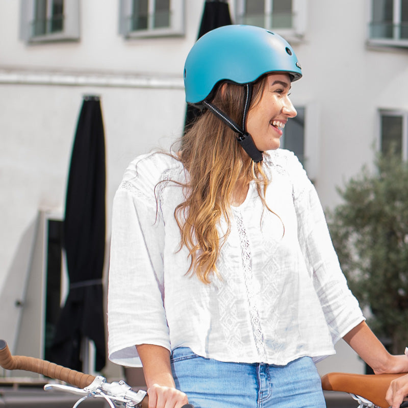 Woman in a white shirt wearing a blue Melon Bicycle Helmet