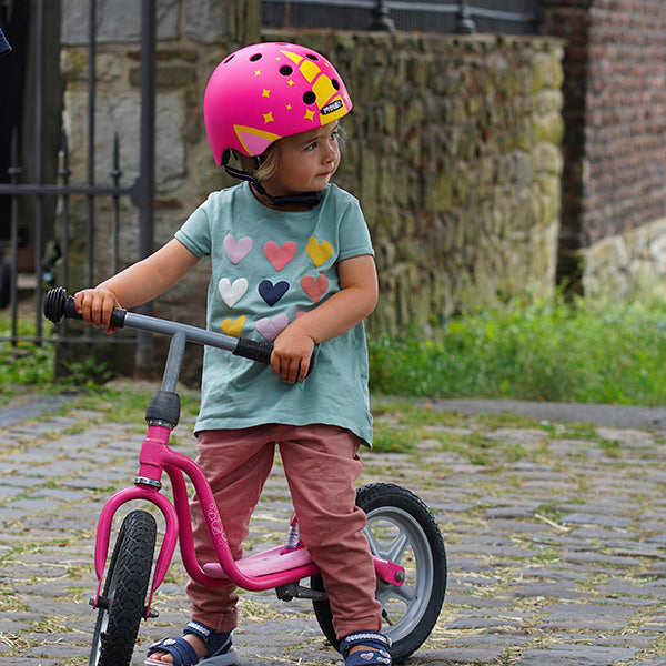Girl sitting on her bicycle wearing a Pink Unicorn Melon Kids Helmet